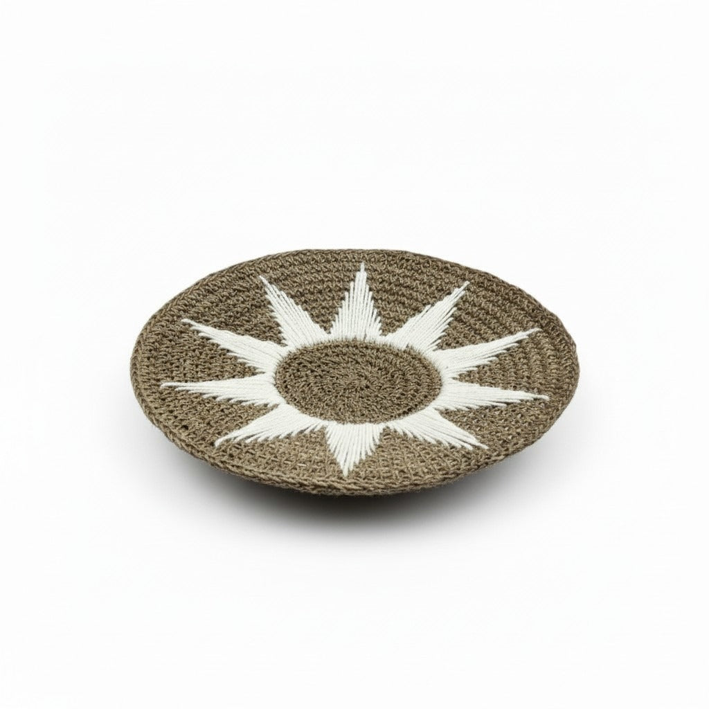 Handgemaakte wanddecoratie uit Bali met een naturel gevlochten structuur en wit zonmotief. De ronde, licht gebogen vorm en het royale formaat van 70 cm maken dit item tot een sfeervolle blikvanger aan de muur.