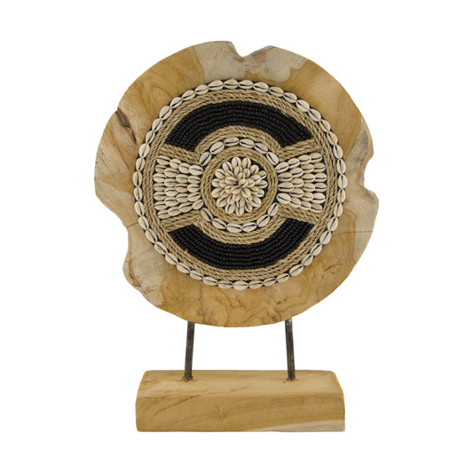 Decoratief rond ornament van teakhout op standaard, afgewerkt met schelpen, gevlochten details en zwarte kralen. Een unieke natuurlijke eyecatcher voor op een kast, dressoir of sidetable.